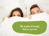 A couple peeking out from under white duvet covers. Voir les images du produit