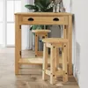 A wooden bar table with two stools in a room with a large plant and window. Anteprima dell’immagine prodotto