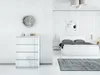 A modern, minimalist bedroom with a white bed, chest of drawers, and abstract wall art. Produktbild-Vorschau