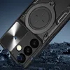 A black phone case with a circular ring stand and camera protection is shown at an angle, with rocks scattered around it. Produktbild-Vorschau