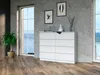 A white dresser with eight drawers is placed in a modern room with a large window and a plant. Produktbild-Vorschau