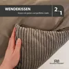 A hand is shown touching a textured pillow, highlighting its features. Produktbild-Vorschau