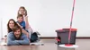 A family is posing on the floor next to a Vileda Easy Wring & Clean mop and bucket set. Produktbild-Vorschau