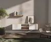 A modern living room scene with a wall-mounted TV lowboard, a plant, and a chair. Produktbild-Vorschau