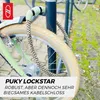 A bicycle lock is attached to a bicycle frame and a bike rack. Voir les images du produit