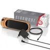 A product shot of a digital alarm clock with a wood-grain finish, its power adapter, and a coiled cable, placed on a white reflective surface with a product box in the background. Produktbild-Vorschau