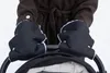 A person wearing a brown coat and black mittens is pushing a stroller in the snow. Náhľad obrázku produktu