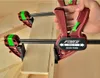 A hand is using a quick clamp to hold two pieces of wood together. Náhled obrázku produktu