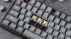 A close-up view of a mechanical keyboard with some keys removed, revealing the switches. Produktbild-Vorschau