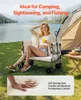 A woman is sitting in a wagon by a lake with a tent in the background. Produktbild-Vorschau