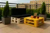 A balcony setting with pallet furniture, drinks, and a laptop. Produktbild-Vorschau