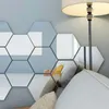 Hexagonal mirror tiles are adhered to a light blue wall above a sofa with pillows and a floor lamp. Produktbild-Vorschau