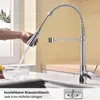 A hand is holding a kitchen faucet with water running into a bowl. Podgląd zdjęcia produktu