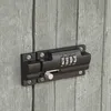 A close-up shot of a black combination lock bolt on a weathered gray wooden door. Produktbild-Vorschau