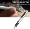 A person is using a USB engraving pen to engrave a design on a shell. The pen is shown in detail in the foreground. Náhled obrázku produktu