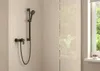 A shower fixture mounted on a tiled wall, with a window and greenery visible through a glass partition. Anteprima dell’immagine prodotto