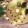 A festive Christmas arrangement with a wooden slice, a star-shaped candle holder, pine cones, and fairy lights. Produktbild-Vorschau