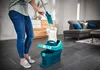 A person is using a mop and bucket in a living room. Produktbild-Vorschau