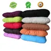 A stack of colorful, soft, rectangular cushions arranged in a staggered formation against a white background. Produktbild-Vorschau