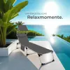 A lounge chair is placed on a patio next to an infinity pool with a view of the ocean. Náhled obrázku produktu