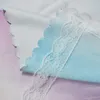 A close-up view of layered fabric with scalloped edges and lace trim. Náhled obrázku produktu