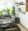 A living room scene with a sofa, coffee table, and a nightstand next to a window. Produktbild-Vorschau