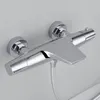 A chrome shower thermostat faucet mounted on a light gray wall. Produktbild-Vorschau