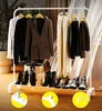 A white metal garment rack displaying various clothing items and shoes. Náhled obrázku produktu