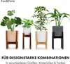Four different potted plants are displayed on white stands against a white background. The plants vary in size and type, and the pots have different designs and colors. Text at the bottom advertises design-strong combinations in various sizes, materials, a Produktbild-Vorschau