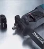 A close-up view of a Makita rotary hammer and a detached chuck on a metallic surface. Podgląd zdjęcia produktu