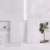 A close-up view of white fabric curtains with text and images visible behind them. Produktbild-Vorschau