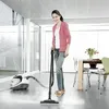 A woman is using a steam cleaner in a modern living room. Produktbild-Vorschau