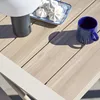 A close-up view of a table setting with a lamp, meringues on a plate, and a blue mug. Produktbild-Vorschau