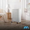 A white oil radiator is placed on a wooden floor next to a wicker chair and a side table with a lamp. Produktbild-Vorschau
