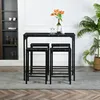 A dining set with a marble-patterned table and four black stools is displayed in a room with a shelf unit and a plant. Náhled obrázku produktu