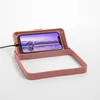 A pink lunchbox with a phone charging inside. Podgląd zdjęcia produktu