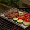 A grill plate with food on it, placed on a grill. Náhled obrázku produktu
