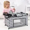 A young girl is playing with a doll's crib set. Produktbild-Vorschau
