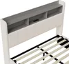 Close-up view of a white bed frame headboard with built-in shelves and a USB port, showing the wooden slats of the bed base. Produktbild-Vorschau