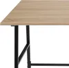 Close-up of a desk with a light wood-like surface and black metal legs. Náhled obrázku produktu