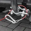 A close-up view of a red safety cable attached to a trailer hitch with a carabiner clip. Produktbild-Vorschau