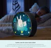 A child sleeping in bed with a night light on a bedside table. Voir les images du produit
