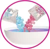 Two pouches of confetti being poured into a bowl of purple water. Náhľad obrázku produktu