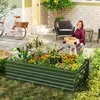 A woman is tending to a raised garden bed filled with flowers and plants in a backyard setting. A bicycle is parked nearby. Voir les images du produit