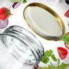 A close-up shot of a glass jar lid and the rim of a glass jar, surrounded by floating salad ingredients. Voir les images du produit