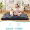A woman and a child are meditating on a dark gray floor mattress in a living room. Náhled obrázku produktu