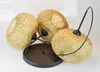 A three-light pendant lamp with bamboo shades on a black base. Náhled obrázku produktu