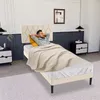 A man relaxing in a bed with a headboard, covered by a blanket, in a bedroom setting. Produktbild-Vorschau