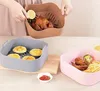 Three silicone inserts for an air fryer are shown, each containing different food items: a whole chicken, egg tarts, and chicken wings with french fries. A hand is holding a lemon slice over the chicken. Anteprima dell’immagine prodotto