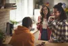 Three friends enjoying coffee together in a kitchen. Anteprima dell’immagine prodotto